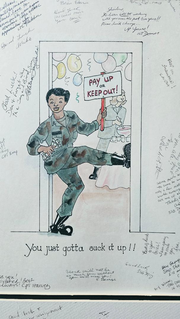 A comical drawing of Shirlene, African American woman with army uniform on and leg up blocking door. She is holding sign says "pay up or keep out" with party people in room behind. "You just gotta suck it up!!" caption below her.